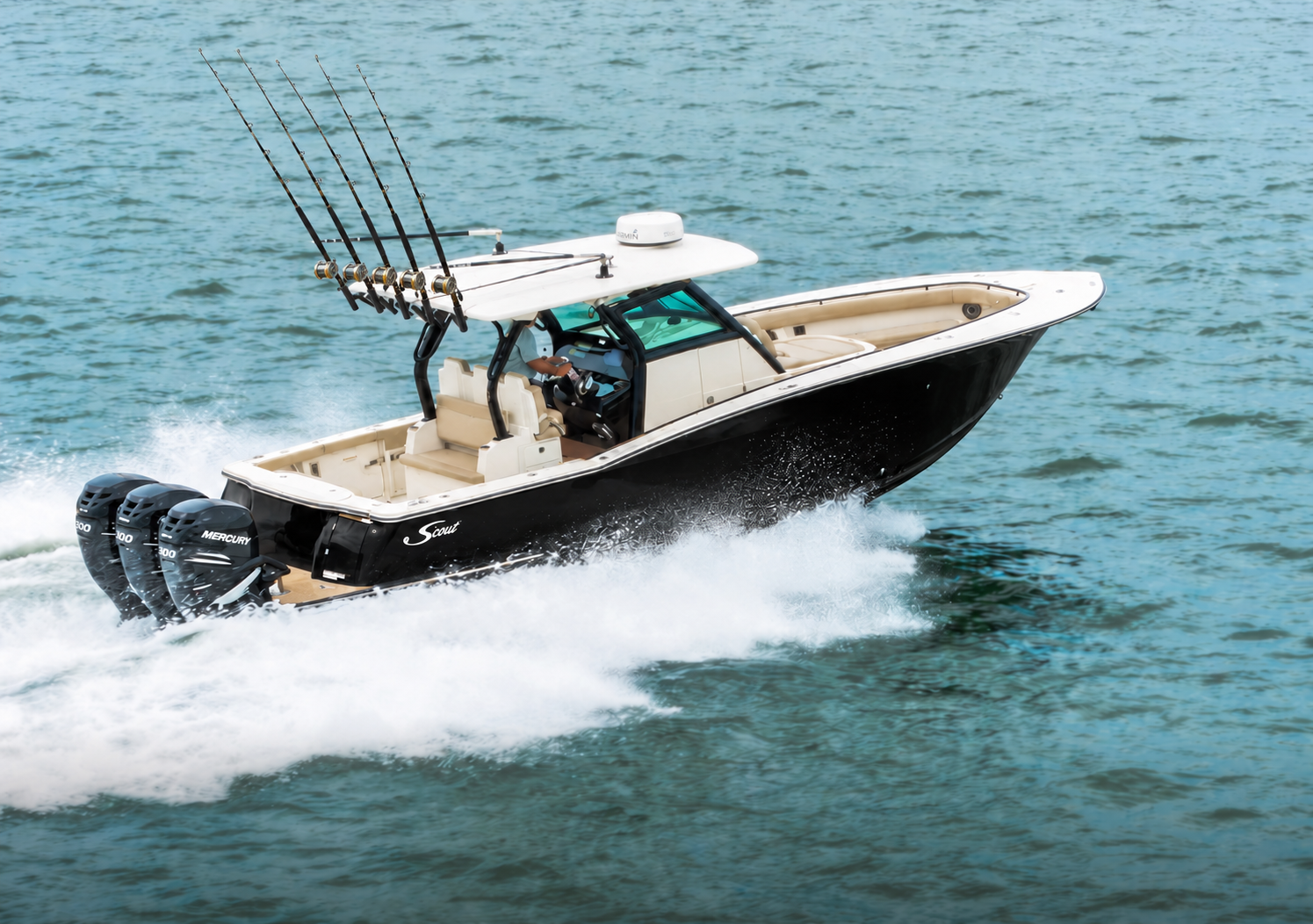 Black Scout offshore boat with five fishing rods and triple outboards underway